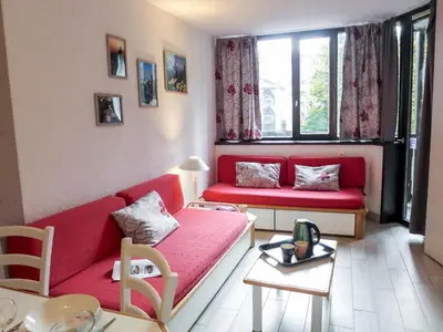 a living room with two red couches and a table at Apartment Jonquilles-7 by Interhome in Chamonix-Mont-Blanc