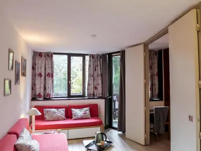 a living room with a red couch in front of a window at Apartment Jonquilles-7 by Interhome in Chamonix-Mont-Blanc