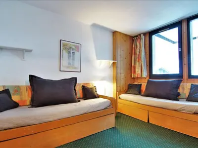 two beds in a room with two windows at Apartment Le Grépon-1 by Interhome in Chamonix-Mont-Blanc