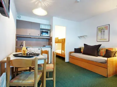 a small room with a bed and a table and a kitchen at Apartment Le Grépon-1 by Interhome in Chamonix-Mont-Blanc