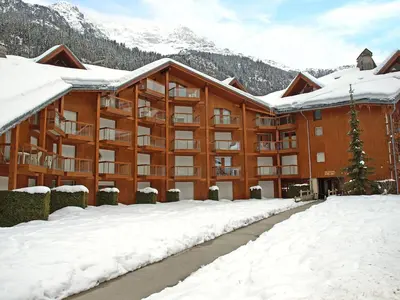 a large apartment building with a mountain in the background at Apartment L'Enclave I et J-7 by Interhome in Les Contamines-Montjoie
