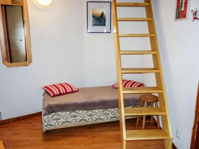 a bedroom with a bed with a plaid blanket at Apartment Le Brûlaz by Interhome in Les Contamines-Montjoie