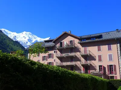 a building with a snow covered mountain in the background at Apartment L'Univers by Interhome in Chamonix-Mont-Blanc