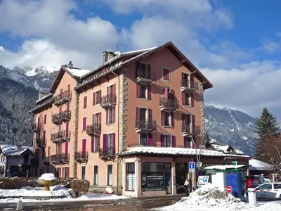 a large building with pink doors and windows in the snow at Apartment L'Univers by Interhome in Chamonix-Mont-Blanc