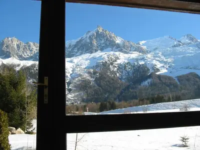 a view of a snowy mountain through a window at Holiday Home Les Pelarnys by Interhome in Chamonix-Mont-Blanc