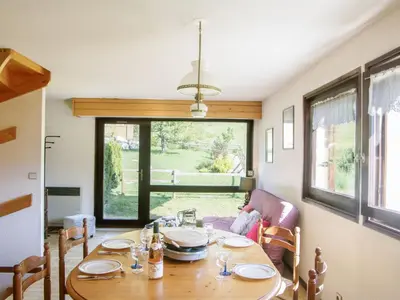 a dining room with a table and a window at Holiday Home Les Pelarnys by Interhome in Chamonix-Mont-Blanc