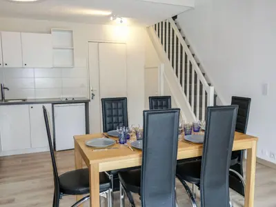 a dining room with a wooden table and black chairs at Apartment La Borgia A- B- C-10 by Interhome in Les Contamines-Montjoie