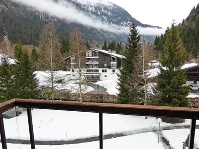 a building covered in snow with mountains in the background at Apartment La Borgia A- B- C-10 by Interhome in Les Contamines-Montjoie