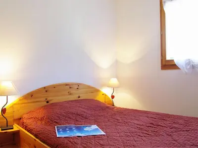 a bedroom with a bed with a book on it at Apartment L'Hermine by Interhome in Les Houches