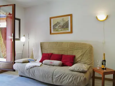 a couch with red pillows in a living room at Studio Les Chamois by Interhome in Les Houches