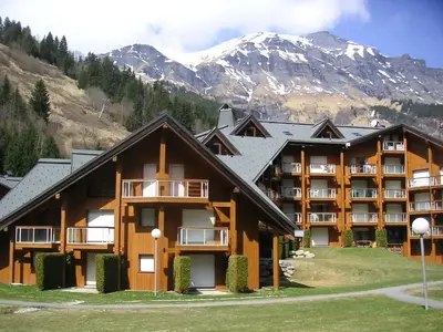 a large apartment building with a mountain in the background at Apartment Les Combettes D et E by Interhome in Les Contamines-Montjoie