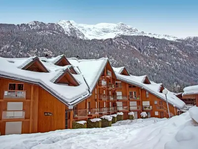 a large building with a mountain in the background at Apartment La Borgia A- B- C-1 by Interhome in Les Contamines-Montjoie