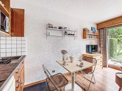 a living room with a couch and a television at Studio Clos du Savoy-22 by Interhome in Chamonix-Mont-Blanc