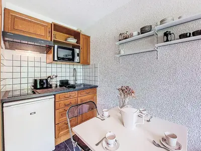 a kitchen with wooden cabinets and a white refrigerator at Studio Clos du Savoy-22 by Interhome in Chamonix-Mont-Blanc