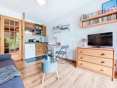 a living room with a blue couch and a table at Studio Clos du Savoy-22 by Interhome in Chamonix-Mont-Blanc