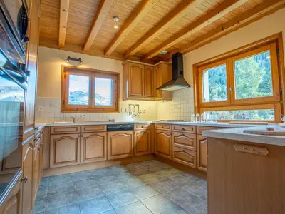 a kitchen with wooden cabinets and a stove top oven at Chalet Chalet Mendiaux by Interhome in Saint-Gervais-les-Bains