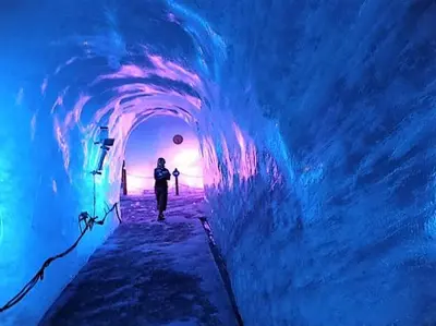 a person walking through an ice tunnel in an ice cave at Saint Gervais - Le Bettex T3 Duplex (1400m d'altitude)/ 55m2 / Vue Mont Blanc - Aux Pieds des Pistes! in Saint-Gervais-les-Bains