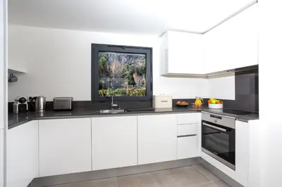 a kitchen with white cabinets and a tv on the wall at La Cordee 504 Apartment - Chamonix All Year in Chamonix-Mont-Blanc