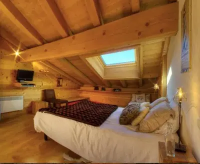 a bedroom with a large bed in a cabin at CHALET CHAM'ROCK in Les Houches