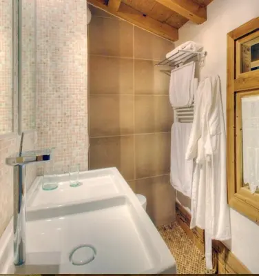 a bathroom with a white sink and towels at CHALET CHAM'ROCK in Les Houches