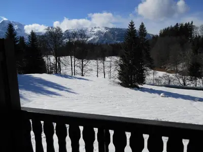 a snow covered yard with a fence and a mountain at LES CARROZ LE LAYS cosy apartment 40M2 vue montagne plein sud in Les Carroz d'Araches