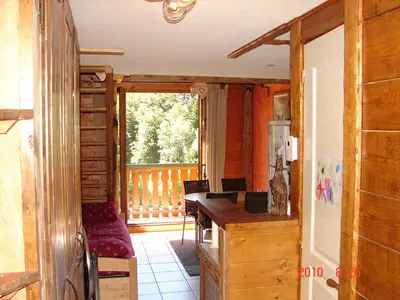 a kitchen with a desk and a balcony at LES CARROZ LE LAYS cosy apartment 40M2 vue montagne plein sud in Les Carroz d'Araches