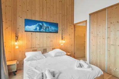 a bedroom with a bed and a tv on the wall at Résidence Luxe 5*,Spa & Fitness, La Cordée Appartement 214 in Chamonix-Mont-Blanc