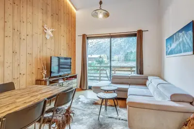 a living room with a couch and a table at Résidence Luxe 5*,Spa & Fitness, La Cordée Appartement 214 in Chamonix-Mont-Blanc