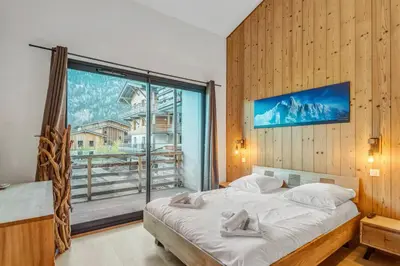a bedroom with a bed and a large window at Résidence Luxe 5*,Spa & Fitness, La Cordée Appartement 214 in Chamonix-Mont-Blanc
