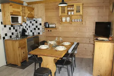 a kitchen with a wooden table in a room at L'Enclave in Les Contamines-Montjoie