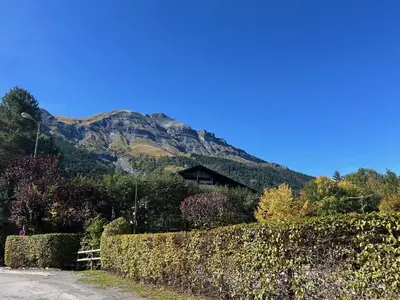a house in front of a mountain with a fence at L'Enclave in Les Contamines-Montjoie