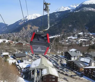 a gondola lift in the air over a city at L'Enclave in Les Contamines-Montjoie