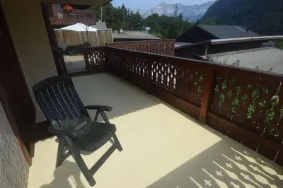 a chair sitting on a balcony with a view at Spacious Apartment 2 Minutes from Ski Lift, Equipped for Babies in Les Houches