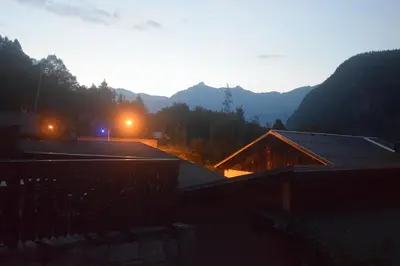 a view of a house with mountains in the background at Spacious Apartment 2 Minutes from Ski Lift, Equipped for Babies in Les Houches