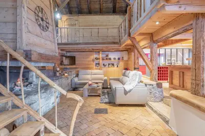 a living room with a fireplace in a wooden house at Le Charmélie 1600 in Flaine