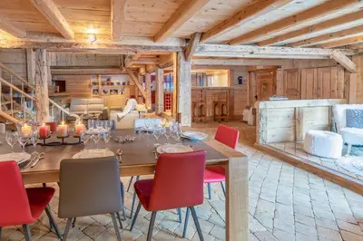 a dining room with a long table and red chairs at Le Charmélie 1600 in Flaine