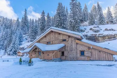 a wooden barn covered in snow with trees at Le Charmélie 1600 in Flaine