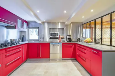 a large kitchen with red cabinets and appliances at Le Charmélie 1600 in Flaine