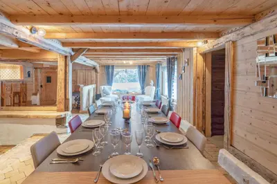 a long dining room with a long table and chairs at Le Charmélie 1600 in Flaine