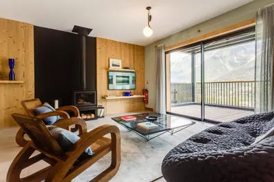 a living room with a couch and a glass table at Le Chalet Mont Blanc in Les Houches