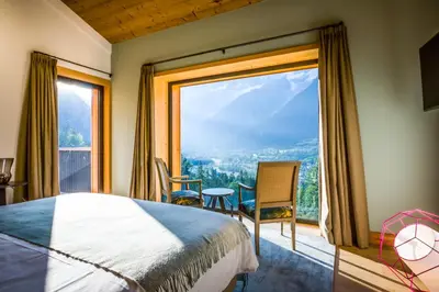 a bedroom with a bed and a large window at Le Chalet Mont Blanc in Les Houches