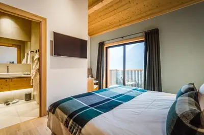 a bedroom with a large bed and a large window at Le Chalet Mont Blanc in Les Houches