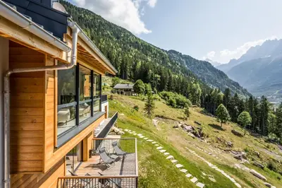 a house with a balcony with a view of mountains at Le Chalet Mont Blanc in Les Houches