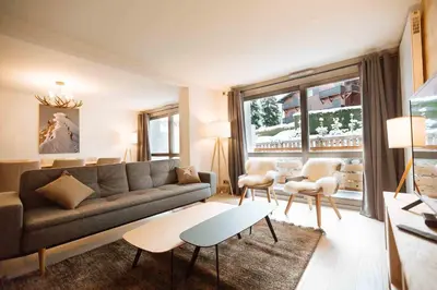 a living room with a couch and a table at Megeve Appartment – Vacances d'hiver – АЕ102 in Megève