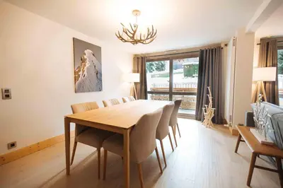 a dining room with a wooden table and chairs at Megeve Appartment – Vacances d'hiver – АЕ102 in Megève