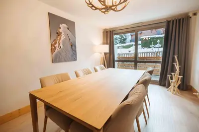 a dining room with a wooden table and chairs at Megeve Appartment – Vacances d'hiver – АЕ102 in Megève