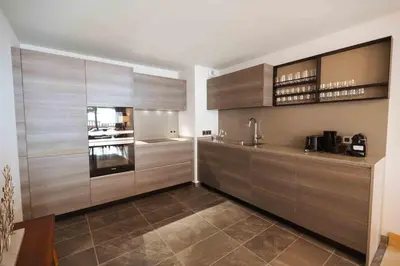 a large kitchen with wooden cabinets and appliances at Megeve Appartment – Vacances d'hiver – АЕ102 in Megève