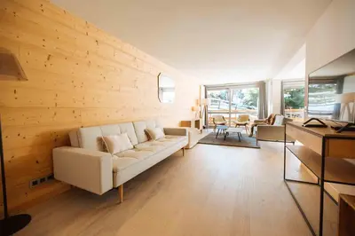 a living room with a white couch and wooden walls at Wonderful 2 bedroms – Vacances Megeve – AW101 in Megève
