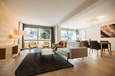 a living room with a couch and a dining room at Wonderful 2 bedroms – Vacances Megeve – AW101 in Megève