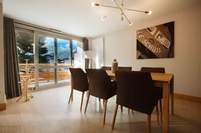 a dining room with a wooden table and chairs at Fabulous Residence Lesporting Ski - AE203 in Megève